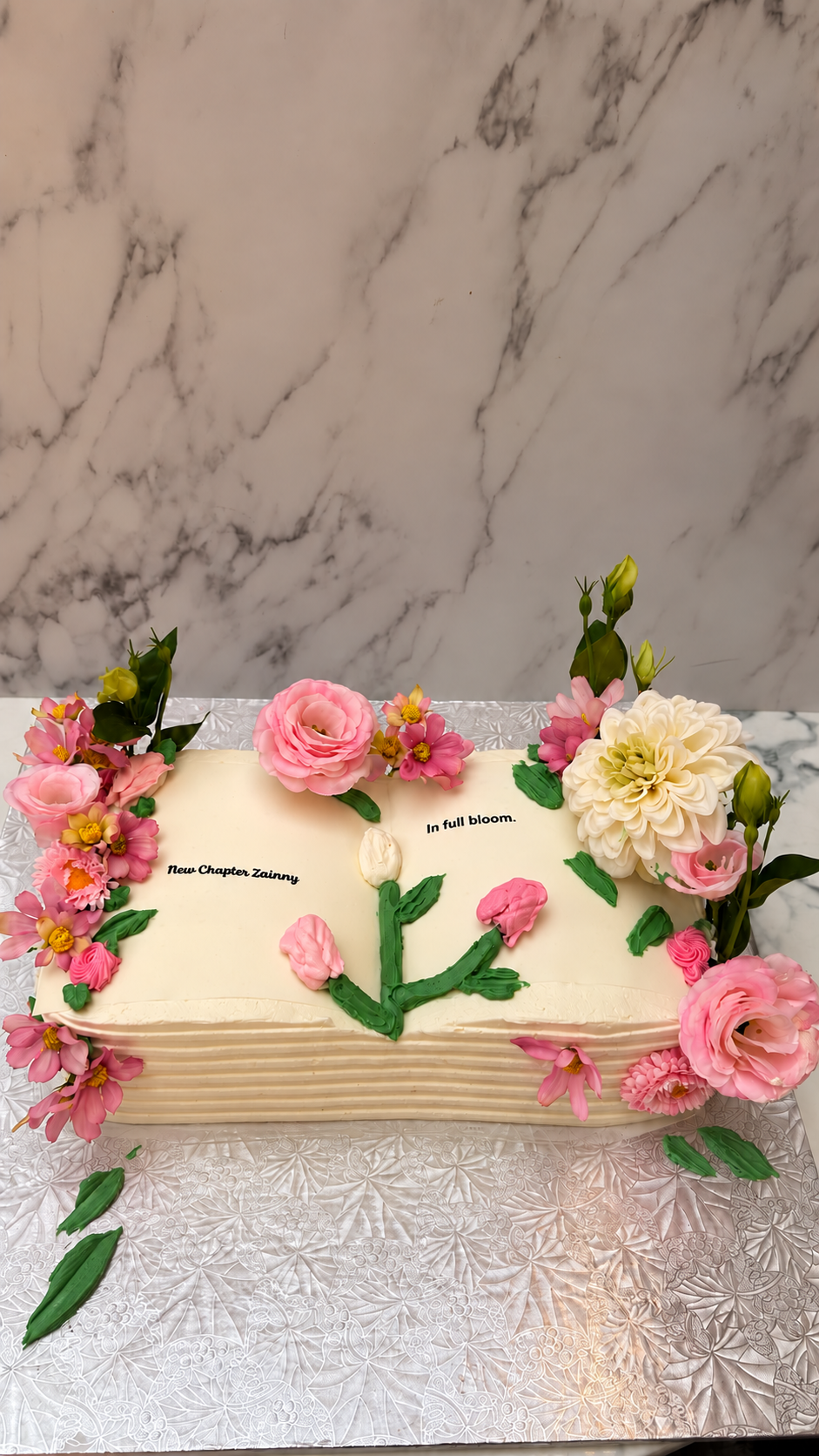 Floral New Chapter Zainny celebration cake on a silver board